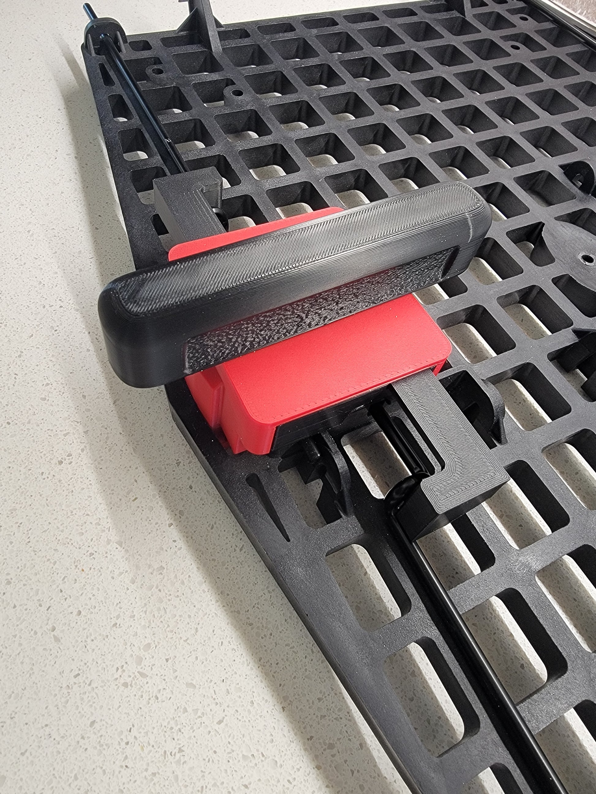 Easy grip lever handle of Ruffland Kennel turn to open door assist opener. Red and black. 